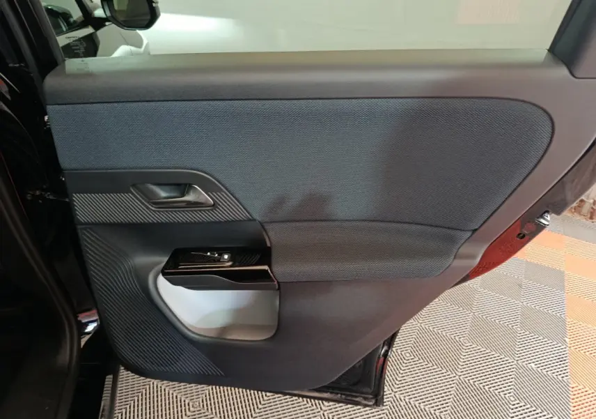 Vue intérieure de la porte arrière gauche noire de la Citroën C5 Hybride 2026 avec habillage textile et plastique.