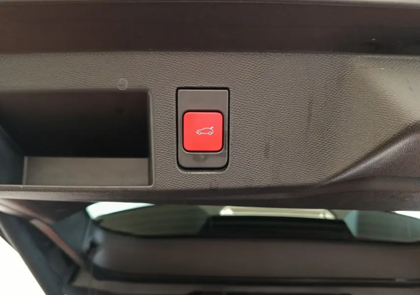 Bouton rouge d'ouverture électrique du coffre sur le hayon intérieur d'une Citroën C5 Hybride noire 2026.