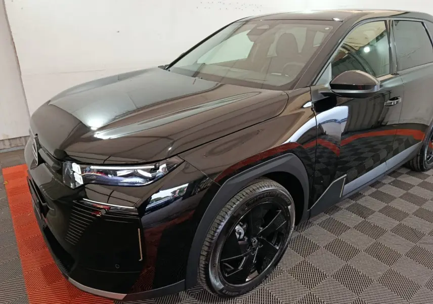 Vue 3/4 avant droit d'une Citroën C5 hybride noire avec phares LED et jantes noires distinctives.