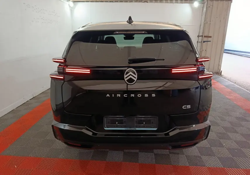 Vue arrière d'un Citroën C5 Aircross noir avec feux LED horizontaux allumés dans un garage.