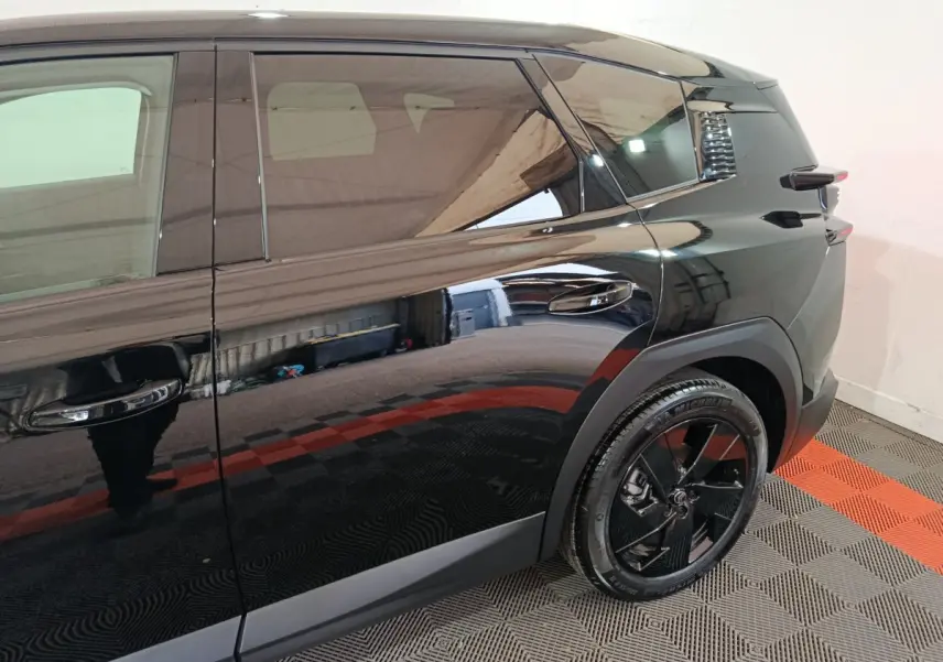Vue latérale droite du Citroën C5 Hybride noir, mettant en valeur la porte arrière et la roue arrière au design moderne.