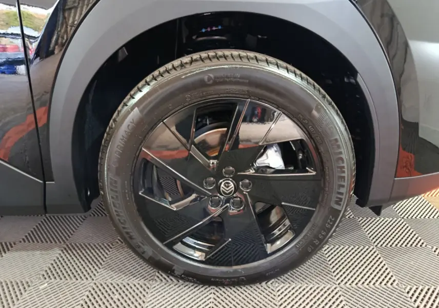Gros plan sur la roue arrière droite noire brillante de la Citroën C5 Hybride 2026 avec jante au design moderne.