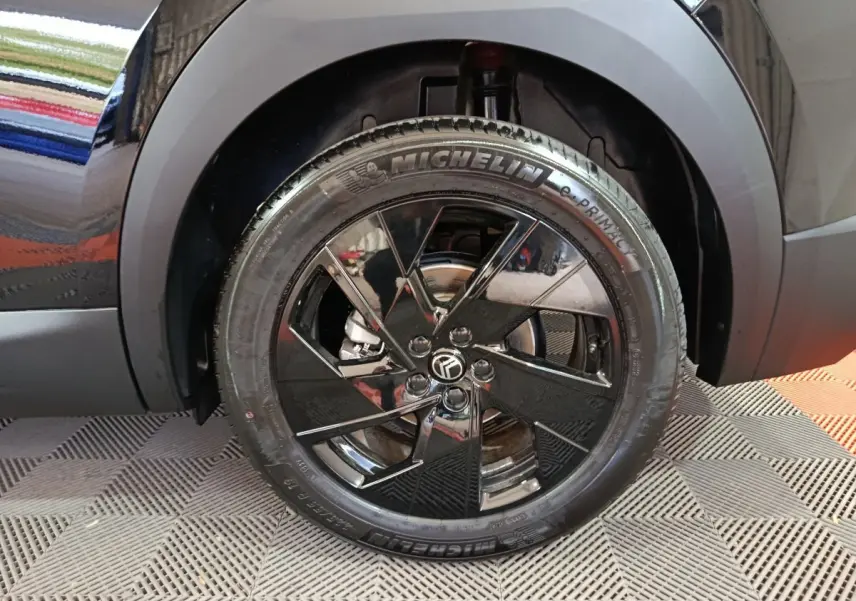 Gros plan sur la roue avant droite noire avec jante en alliage brillant du Citroën C5 Hybride 2026.