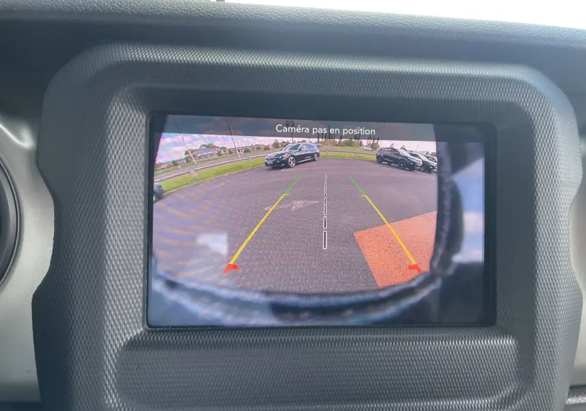 Écran de caméra de recul du Jeep Wrangler blanc 2018 montrant l'arrière avec lignes de guidage colorées.