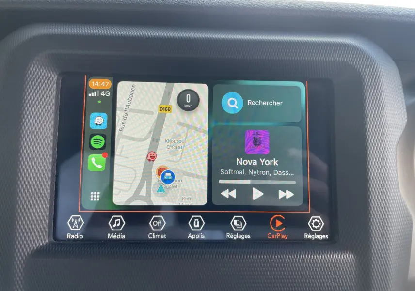 Écran tactile du système multimédia de la Jeep Wrangler 2018 affichant la navigation et la musique via Apple CarPlay.
