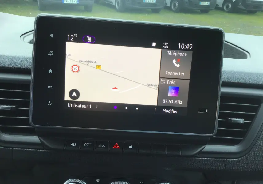 Vue rapprochée de l’écran tactile central du Renault Trafic Fourgon noir, affichant la navigation et les commandes multimédia.