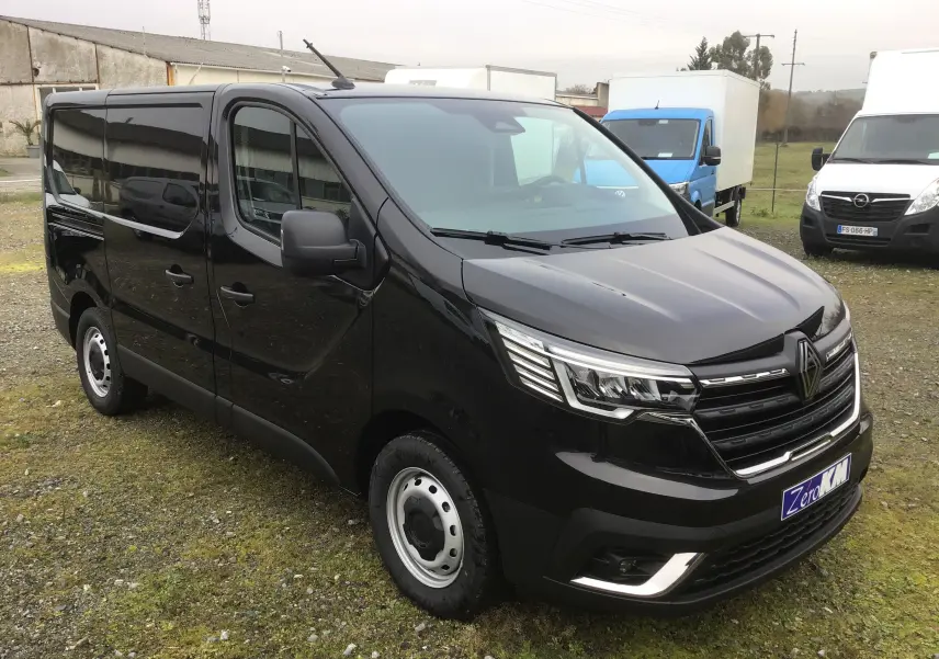 Vue 3/4 avant droite d'un Renault Trafic Fourgon noir 2025 avec calandre distinctive et phares LED.