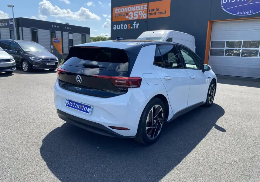 Vue 3/4 arrière droite d'un Volkswagen ID.3 blanc glacier métallisé avec toit noir et jantes stylisées.