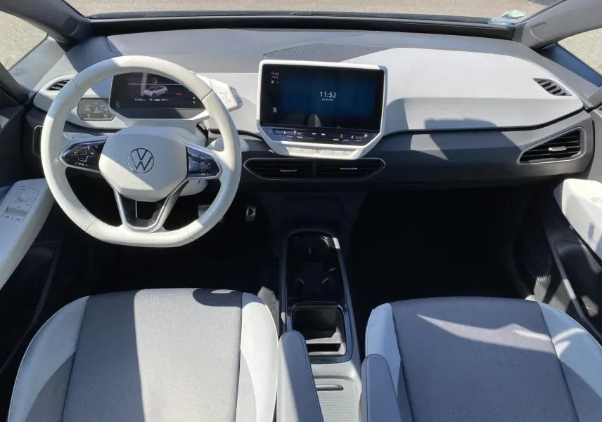 Intérieur du Volkswagen ID.3 Pro Performance vu de dessus, tableau de bord clair et sièges tissu gris avec accoudoirs.