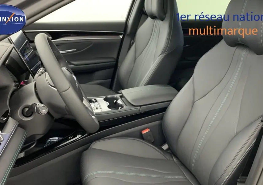 Vue intérieure côté conducteur du BYD SEAL U 2025 en cuir noir avec surpiqûres vertes et tableau de bord moderne.