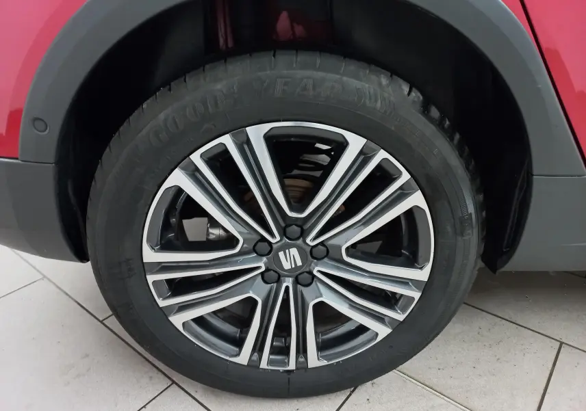 Gros plan sur la jante alliage bicolore du côté arrière droit d’un SEAT Arona rouge Désir avec toit noir Minuit.