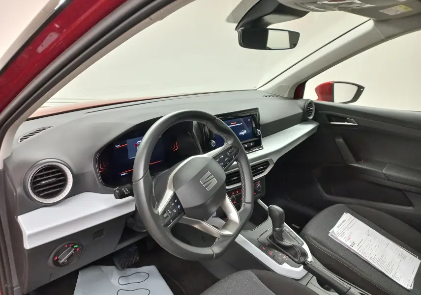Vue intérieure côté conducteur du SEAT Arona rouge Désir avec tableau de bord moderne et boîte automatique DSG7.