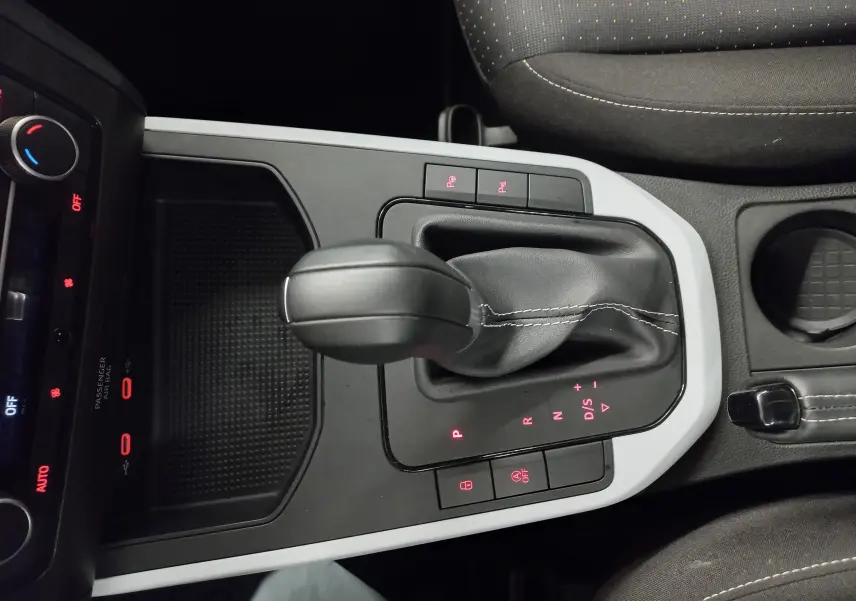 Gros plan sur la console centrale de la SEAT Arona 2025 avec levier de boîte automatique et éclairage rouge des commandes.