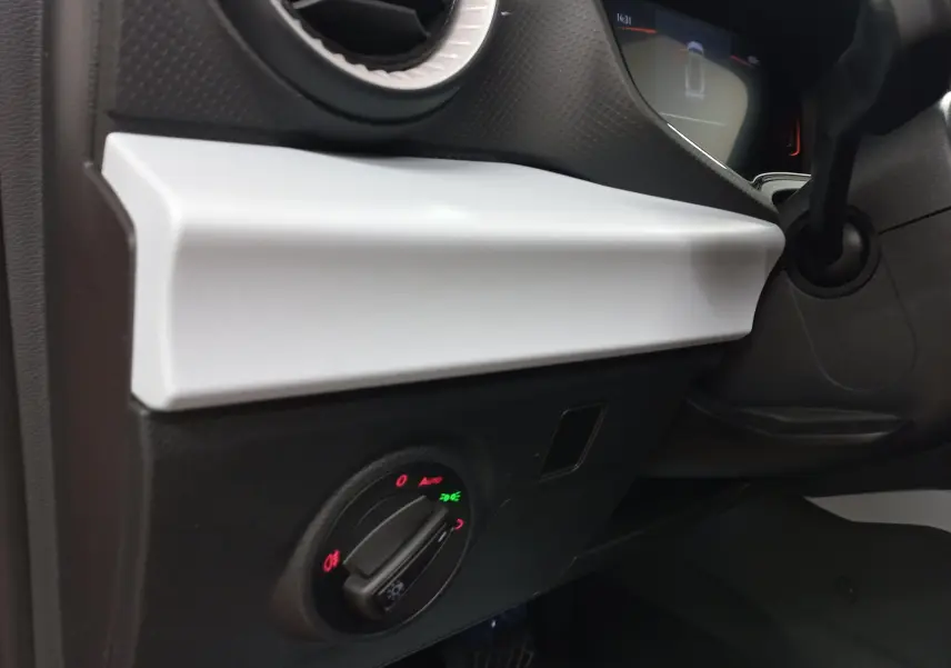 Détail intérieur côté gauche du tableau de bord du SEAT Arona 2025 avec commande des phares et finition blanche.
