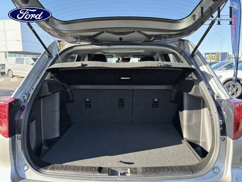 Coffre ouvert vu de l'arrière d'un Suzuki Vitara Galactic Gray métallisé avec intérieur noir et tablette cache-bagages.