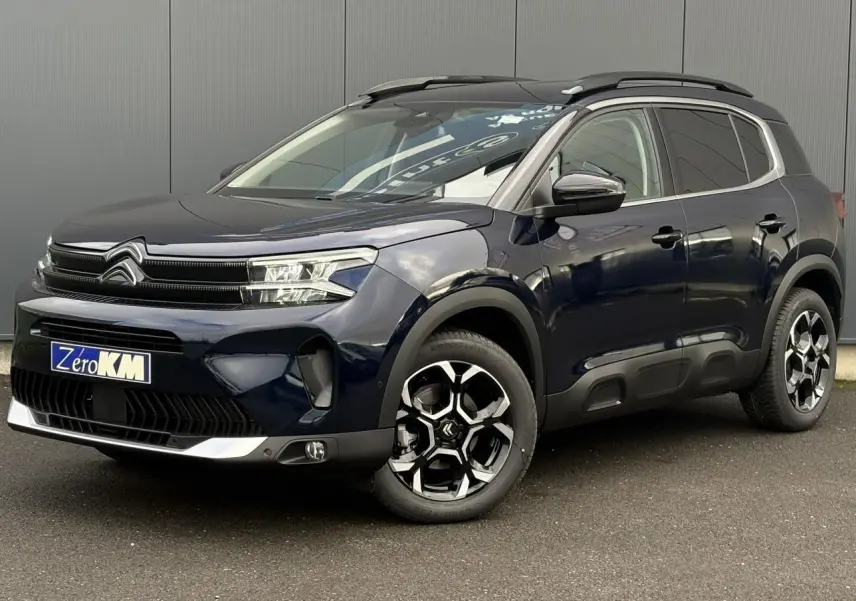 Citroën C5 Aircross Bleu Eclipse en 3/4 avant droit, avec jantes bi-ton et barres de toit noires brillantes.
