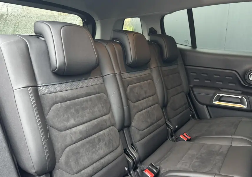 Vue intérieure des trois sièges arrière en Alcantara noir du Citroën C5 Aircross 2025, avec appuie-têtes et ceintures visibles.