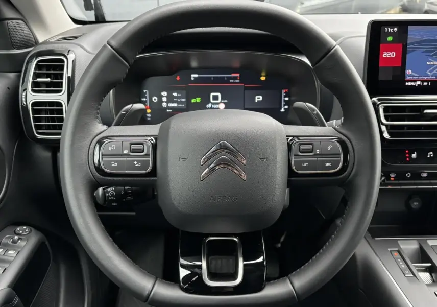 Vue frontale centrée sur le volant cuir noir du Citroën C5 Aircross 2025 avec combiné numérique et écran tactile.