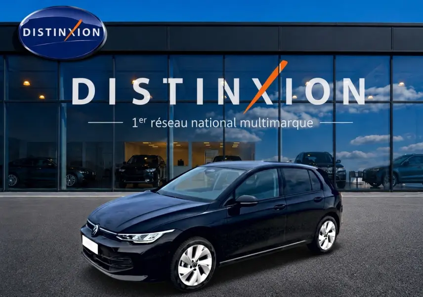 Volkswagen Golf noir vue 3/4 avant droit, avec jantes alu 17 pouces, devant une vitrine Distinxion.