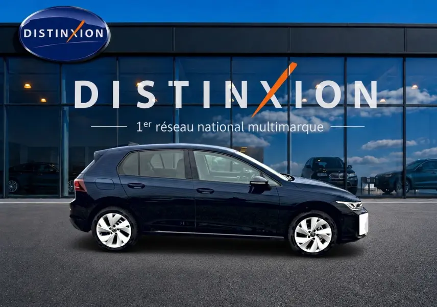 Profil côté gauche d'une Volkswagen Golf noire 2026 garée devant une vitrine avec logo Distinxion.