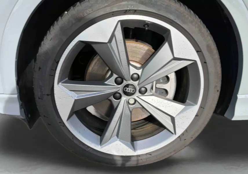 Gros plan sur la jante 19 pouces à 5 branches en étoile grise du côté avant droit de l'Audi Q4 e-tron gris galet.