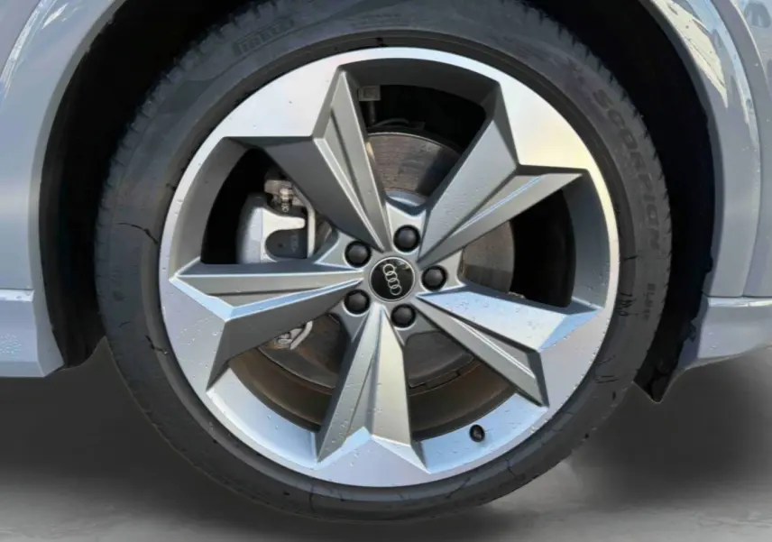 Gros plan sur la jante 19 pouces à 5 bras en étoile de l'Audi Q4 e-tron gris galet, avec pneu Pirelli visible.