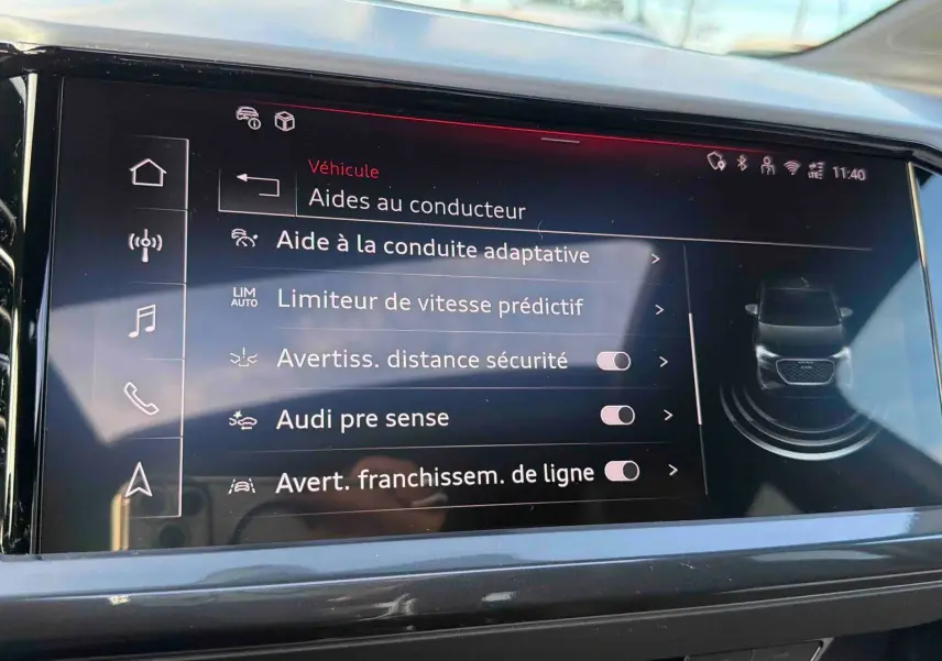 Écran tactile du système MMI Navigation plus dans l'Audi Q4 e-tron 45 gris galet, affichant les aides à la conduite.