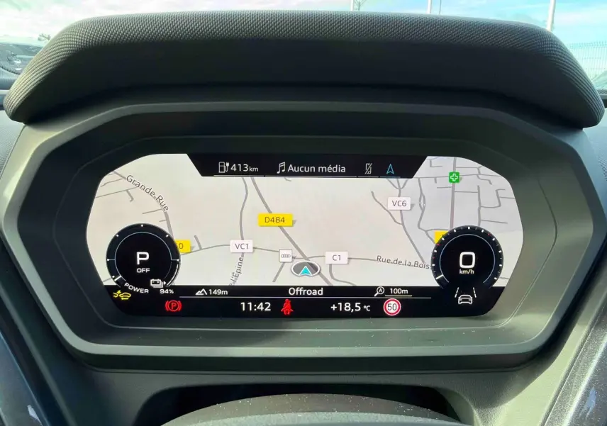 Vue rapprochée du tableau de bord numérique de l'Audi Q4 e-tron 45 gris galet, affichant la navigation et les informations de conduite.
