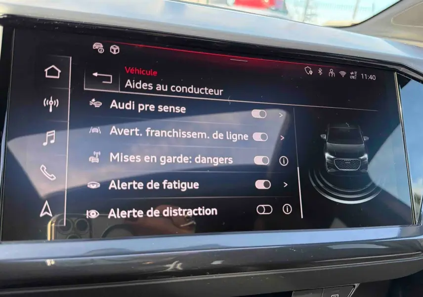 Écran tactile central affichant les aides à la conduite dans l'habitacle gris d'un Audi Q4 e-tron 2025.