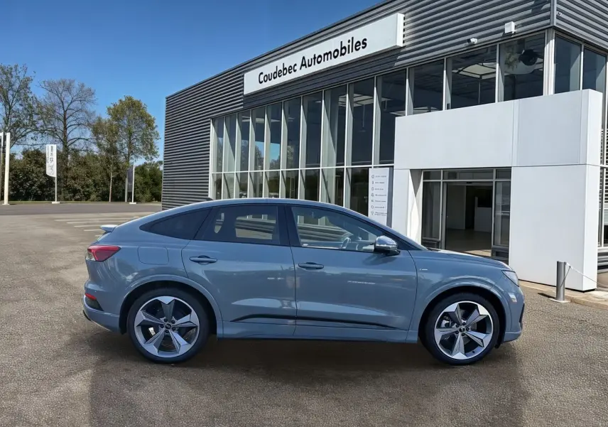 Audi Q4 e-tron gris galet vue de profil côté gauche, avec jantes 19 pouces et lignes fluides de SUV électrique.