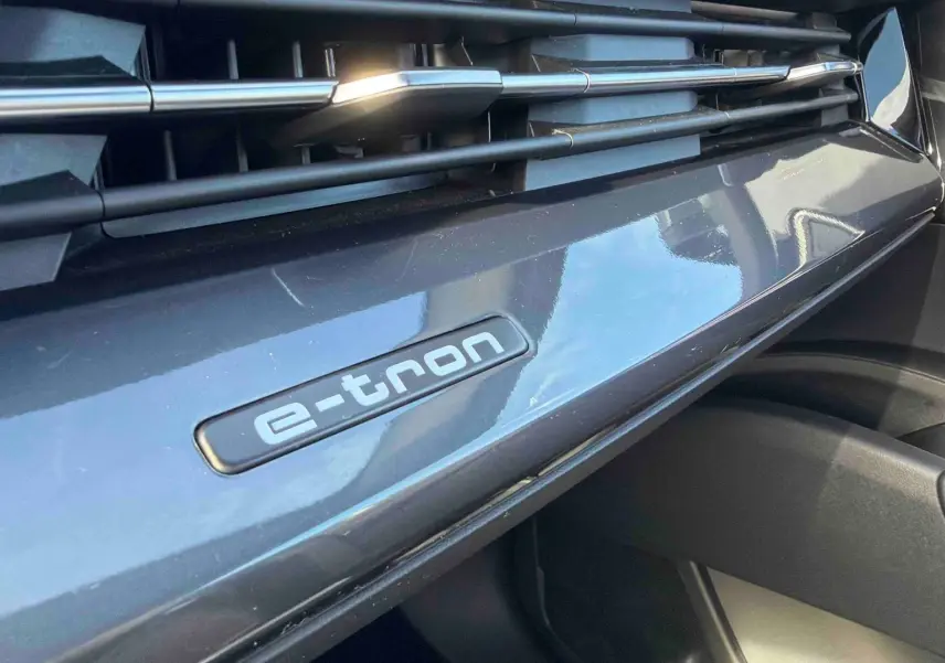 Détail intérieur du tableau de bord gris galet avec logo e-tron sur Audi Q4 e-tron 2025.