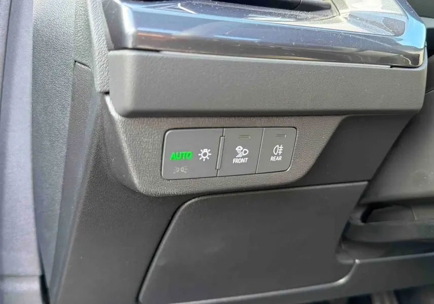Détail des commandes d'éclairage côté gauche du tableau de bord d'un Audi Q4 e-tron gris galet 2025.