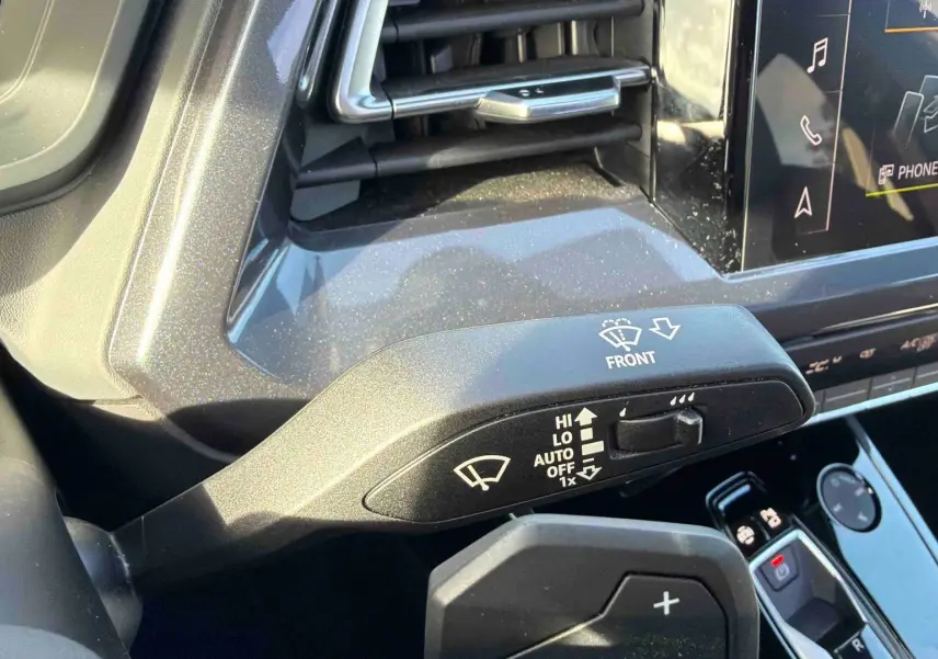 Gros plan sur la commande d’essuie-glace côté gauche dans l’habitacle gris d’un Audi Q4 e-tron 2025.