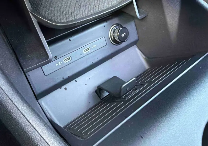 Gros plan sur la console centrale noire de l'Audi Q4 e-tron 2025, montrant ports USB-C et prise 12V.