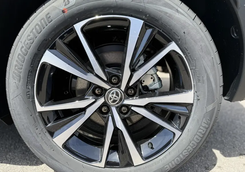 Gros plan sur la jante alliage noire et argentée du Toyota C-HR 1.8 Hybride 140 Style gris Atlas de 2025.