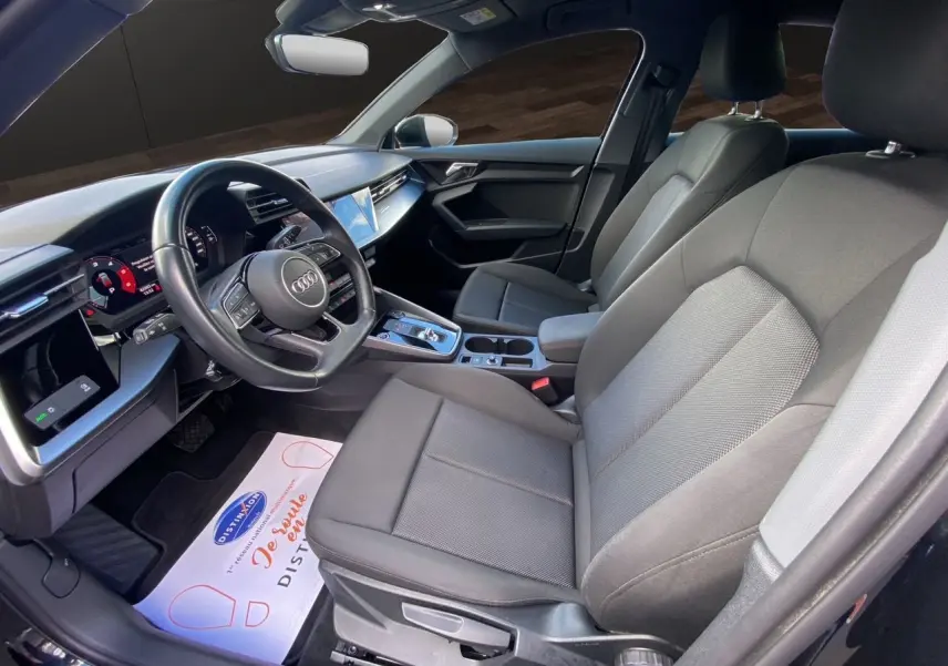 Intérieur noir de l'Audi A3 Sportback 2021 vu côté conducteur, avec tableau de bord digital et sièges tissu.