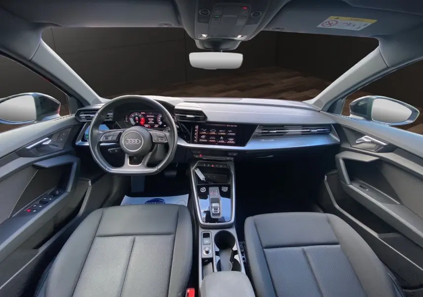 Intérieur noir de l'Audi A3 Sportback 2021, vue avant sur le tableau de bord, volant multifonction et console centrale moderne.