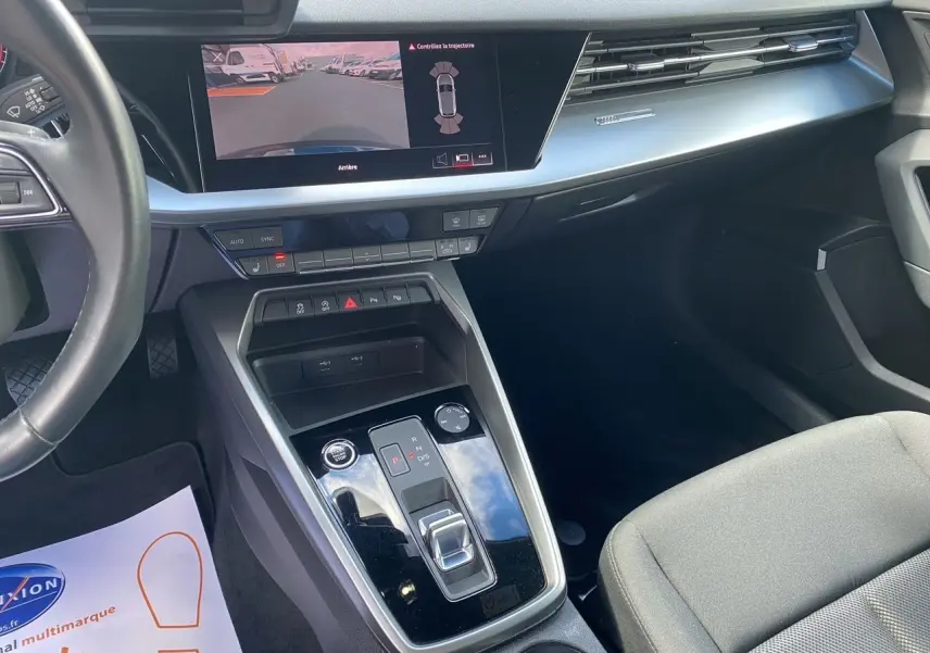 Vue intérieure côté passager de l'Audi A3 Sportback 2021 avec écran caméra de recul et console centrale noire brillante.