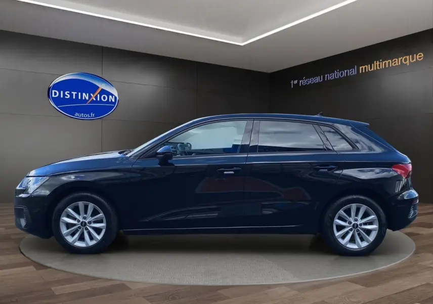 Profil côté gauche d'une Audi A3 Sportback noire 2021, en intérieur sur socle rotatif avec jantes argentées.