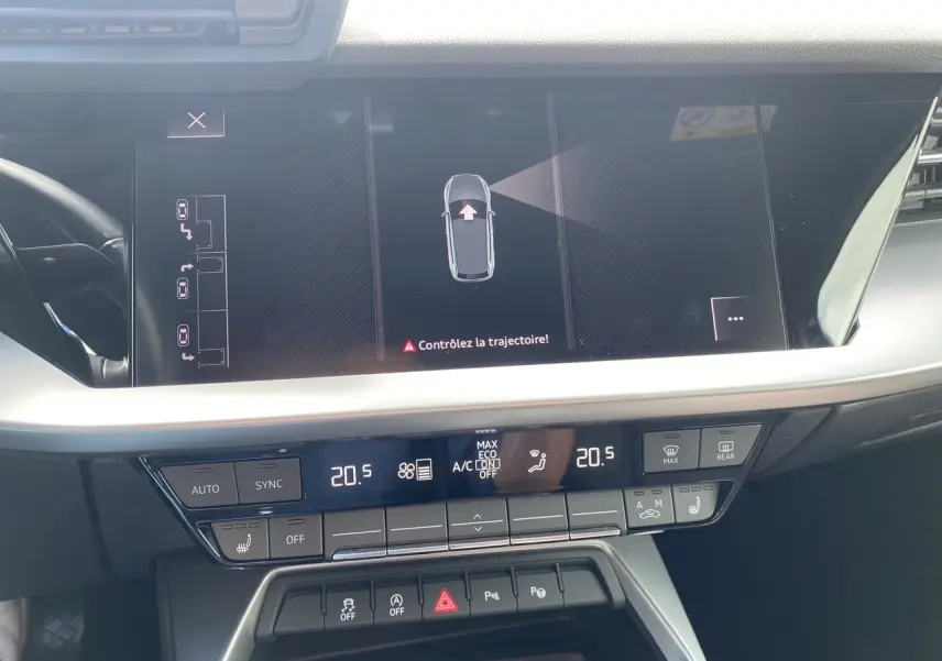 Vue rapprochée de l'écran central et de la console de l'Audi A3 Sportback noire, affichant la caméra de recul et la climatisation.