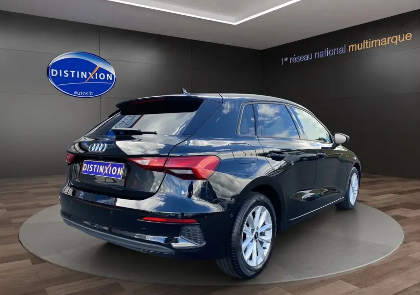 Audi A3 Sportback noir vue 3/4 arrière droit, avec jantes argentées et caméra de recul visible sur le hayon.