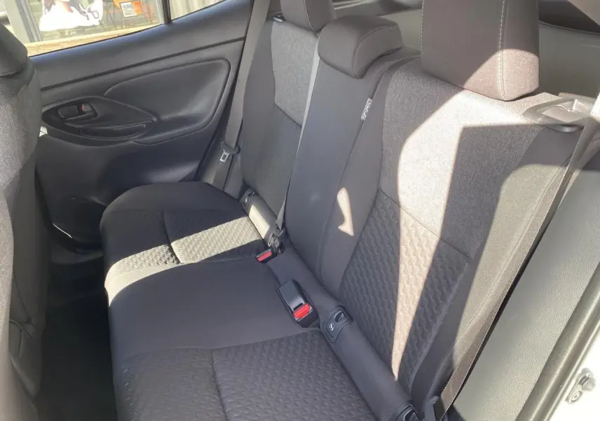 Vue intérieure côté droit des sièges arrière en tissu gris de la Toyota Yaris Cross 2025 blanche.