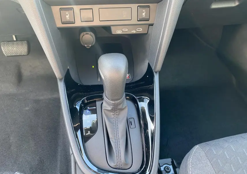 Le levier de vitesse automatique gris de la Toyota Yaris Cross 2025 vu de dessus avec ports USB-C et commandes chauffantes.