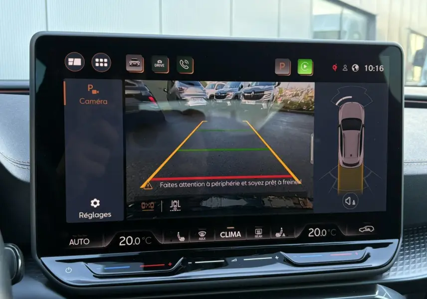 Écran tactile intérieur affichant la caméra de recul avec vue arrière et aides au stationnement du CUPRA Formentor gris.