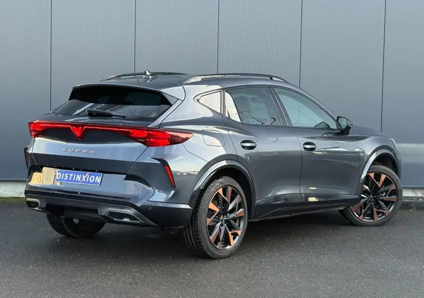 Vue 3/4 arrière droite d'un CUPRA Formentor gris magnétique avec jantes alliage cuivrées et feux arrière LED distinctifs.