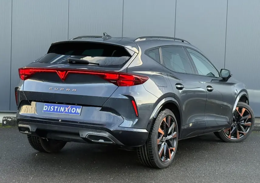 Vue 3/4 arrière droite d'une CUPRA Formentor gris magnétique avec jantes alliage 19'' cuivrées et feux arrière LED triangulaires.