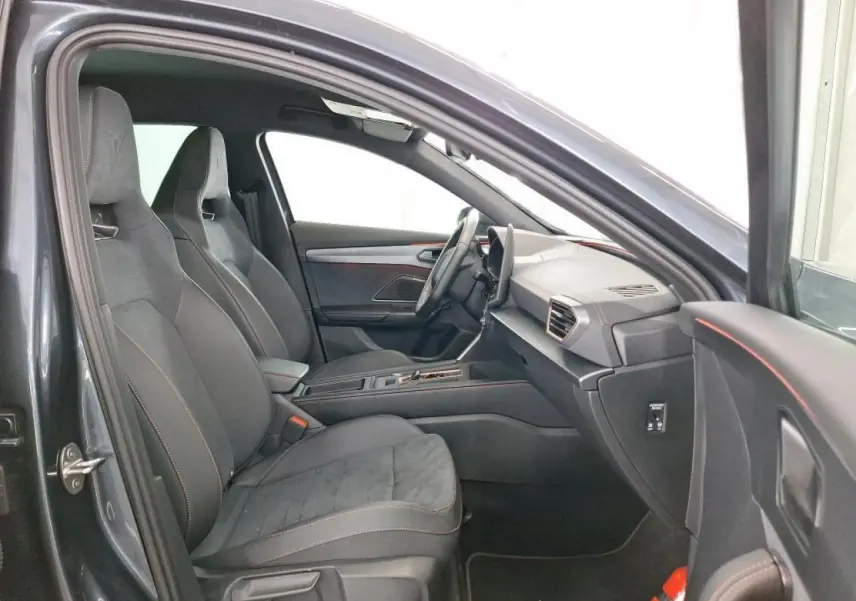 Intérieur de la CUPRA Formentor 2024 en gris, vue côté gauche montrant sièges baquets suédine noirs et tableau de bord moderne.