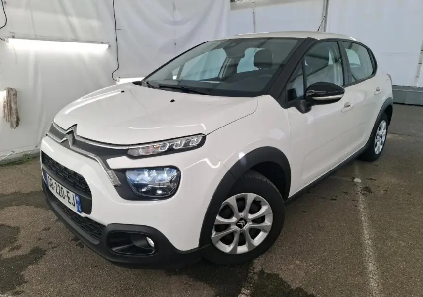 Citroën C3 blanche vue 3/4 avant droit, avec coques de rétroviseurs noires et enjoliveurs 15 pouces.