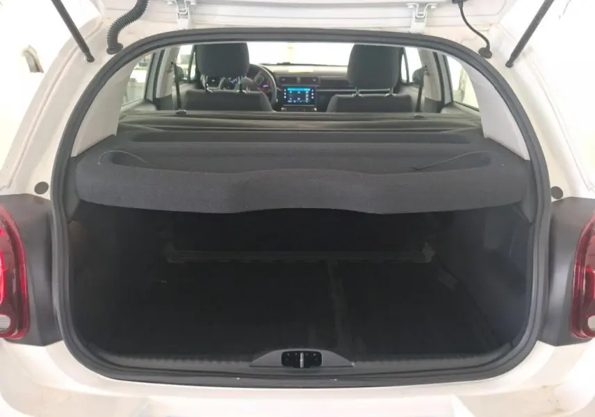 Coffre ouvert d'une Citroën C3 blanche vue de l'arrière, avec tablette cache-bagages et intérieur noir visible.