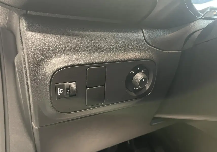 Vue rapprochée des commandes de réglage des phares et des rétroviseurs côté gauche d’un Citroën C3 blanc.